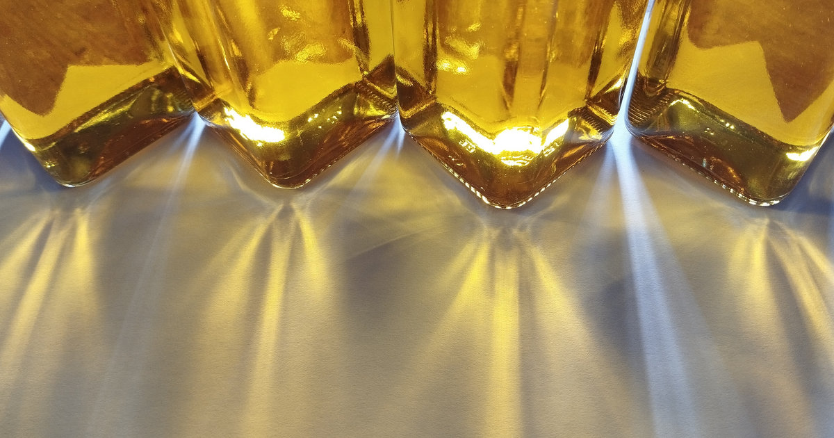 le soleil passe à travers des bouteilles pleines d'huile d'olive